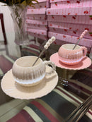 Xícaras branca e rosa com pires e colher