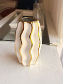 Detalhe do acabamento ondulado branco e dourado do vaso de porcelana
