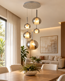 Lustre pendente com cinco globos de vidro fumê instalado em sala de jantar