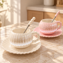 Xícaras de porcelana perolada branca e rosa com pires e colher em ambiente elegante